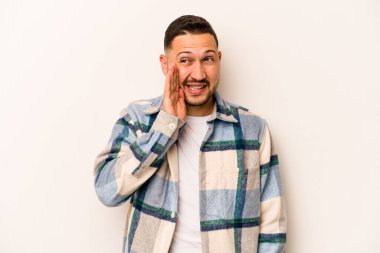 Beyaz arka planda izole edilmiş genç İspanyol adam heyecanlı bir şekilde bağırıyor..