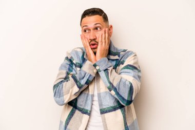 Beyaz arka planda izole edilmiş genç İspanyol adam korkmuş ve korkmuş..