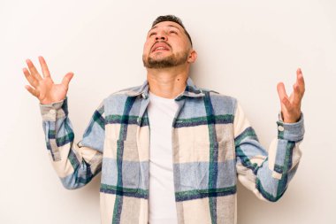 Beyaz arka planda izole edilmiş genç İspanyol adam gökyüzüne haykırıyor, yukarı bakıyor, hayal kırıklığına uğramış..