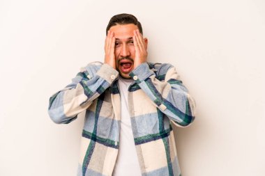 Beyaz arka planda izole edilmiş, yüzünün yarısını palmiye ile örterek eğlenen genç bir İspanyol..