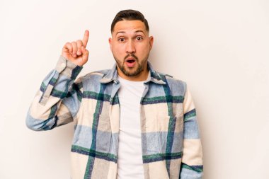 Beyaz arka planda izole edilmiş genç bir İspanyol ağzı açık bir şekilde yukarı işaret ediyor..
