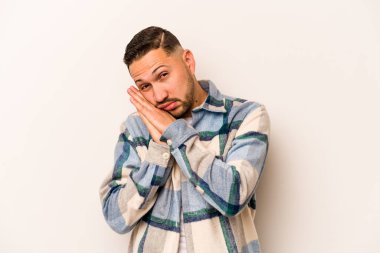 Beyaz arka planda izole edilmiş genç İspanyol adam esniyor. Ağzı eliyle kapatan yorgun bir hareket sergiliyor..