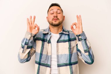 Beyaz arka planda izole olmuş genç İspanyol adam sıkı çalışma gününden sonra rahatlıyor, yoga yapıyor..