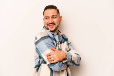 Beyaz arka planda yaşayan genç İspanyol adam gülüyor ve eğleniyor..