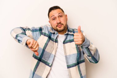 Beyaz arka planda izole edilmiş genç bir İspanyol, baş parmağını kaldırıyor, zor bir seçim.