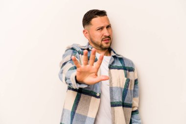 Beyaz arka planda izole edilmiş genç bir İspanyol, yakın bir tehlike nedeniyle şok oluyor.