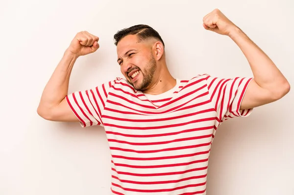 Beyaz arka planda izole edilmiş genç İspanyol bir adam zaferden sonra yumruk kaldırıyor, kazanan konsept..