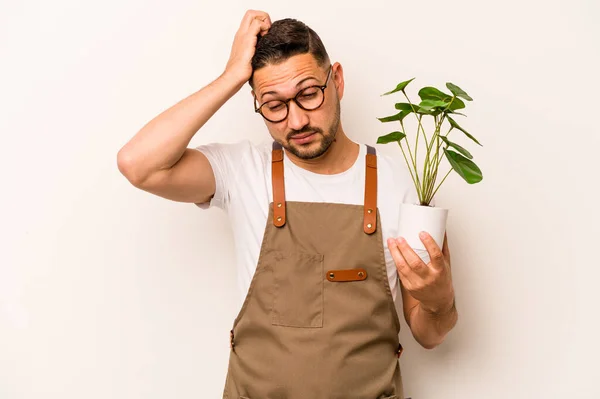 Hispanic Gardener Man Holding Plant Isolated White Background Being Shocked — Foto Stock