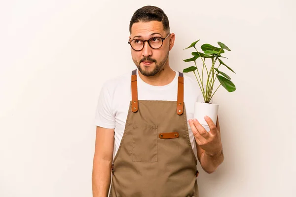 Hispanic Gardener Man Holding Plant Isolated White Background Confused Feels — Foto Stock