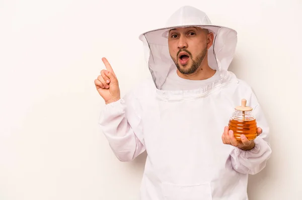 Hispánský Včelař Muž Drží Med Izolovaný Bílém Pozadí Ukazuje Strany — Stock fotografie