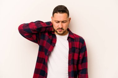 Beyaz arka planda izole edilmiş genç İspanyol bir adam stresten dolayı boynu ağrıyor, masaj yapıyor ve elle dokunuyor..