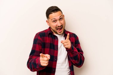 Beyaz arka planda izole edilmiş genç İspanyol adam parmaklarıyla ön tarafı işaret ediyor..