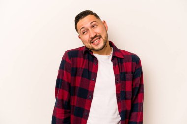 Beyaz arka planda izole edilmiş genç İspanyol adam gülüyor ve gözlerini kapıyor, rahatlamış ve mutlu hissediyor..