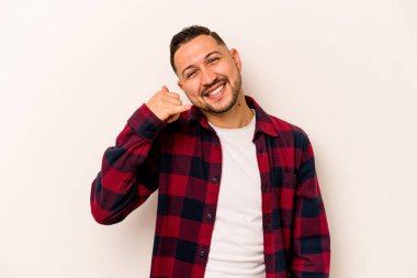 Beyaz arka planda izole edilmiş genç bir İspanyol, parmakları olan bir cep telefonu hareketi gösteriyor..