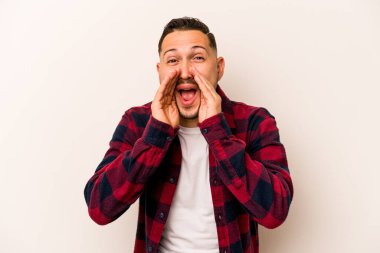 Latin kökenli genç bir adam beyaz arka planda izole edilmiş. Dedikodu yapıyor, bir şeyleri bildiriyor..