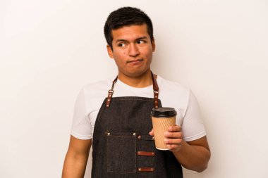 İspanyol restoranın garsonu elinde beyaz arka planda izole edilmiş kahve tutuyor. Kafası karışık ve kararsız..