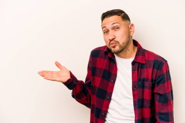 Beyaz arka planda izole edilmiş genç İspanyol bir adam bir avuç içinde fotokopi alanı ve belinde bir el daha gösteriyor..