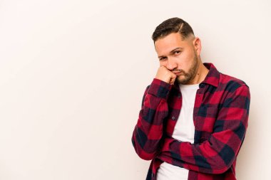 Beyaz arka planda izole edilmiş, üzgün ve dalgın hisseden genç bir İspanyol fotokopi odasına bakıyor..