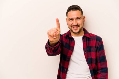 Beyaz arka planda izole edilmiş genç İspanyol bir numara parmağıyla görünüyor..