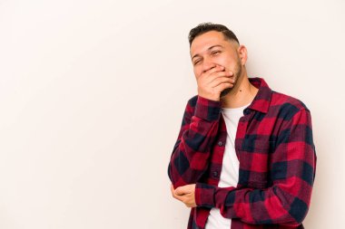 Beyaz arka planda izole olmuş genç bir İspanyol güler, kaygısız, doğal bir duygu..