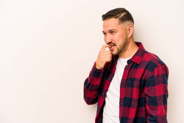 Beyaz arka planda izole edilmiş genç İspanyol bir adam rahatlamış bir şeyin fotokopi odasına baktığını düşünüyor..