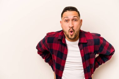 Beyaz arka planda izole edilmiş genç İspanyol adam gördüğü bir şey yüzünden şoka uğruyor..