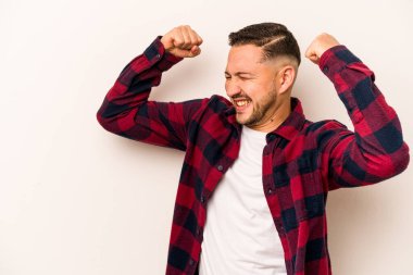 Beyaz arka planda izole edilmiş genç İspanyol bir adam zaferden sonra yumruk kaldırıyor, kazanan konsept..