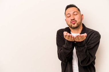 Beyaz arka planda izole edilmiş, dudakları kıvrılmış ve hava öpücüğü yollamak için avuç içi tutan İspanyol bir adam..