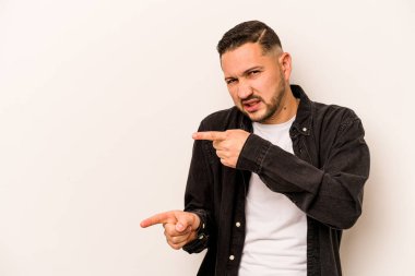 Beyaz arka planda izole edilmiş genç İspanyol adam işaret parmaklarıyla fotokopi alanını işaret ederek heyecan ve arzuyu ifade ediyor..