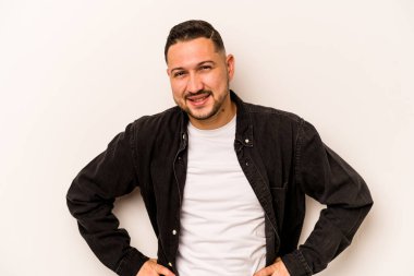 Beyaz arka planda izole edilmiş genç İspanyol adam mutlu, güler yüzlü ve neşeli.