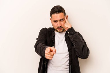 Beyaz arka planda izole edilmiş genç İspanyol bir adam şakağı parmağıyla işaret ediyor, düşünüyor ve bir göreve odaklanıyor..
