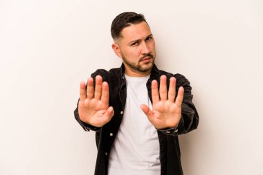 Beyaz arka planda izole edilmiş genç İspanyol adam elini uzatmış, dur işareti göstererek seni engelliyor..