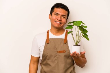 Genç bahçıvan İspanyol bir çiçek tutuyor beyaz arka planda mutlu, güler yüzlü ve neşeli..