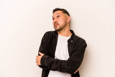 Beyaz arka planda izole edilmiş genç İspanyol adam hedeflere ve amaçlara ulaşma hayali kuruyor.