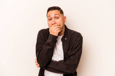 Beyaz arka planda izole edilmiş genç İspanyol adam korkmuş ve korkmuş..