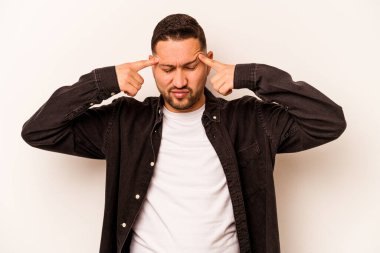 Beyaz arka planda izole edilmiş genç İspanyol bir adam bir göreve odaklanmış, işaret parmaklarını işaret ediyor..