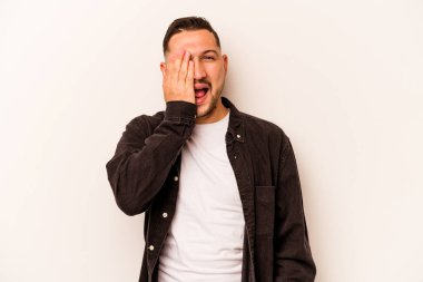 Beyaz arka planda izole edilmiş, yüzünün yarısını palmiye ile örterek eğlenen genç bir İspanyol..