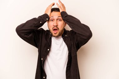 Beyaz arka planda izole edilmiş genç bir İspanyol şaşırmış ve şok olmuş..