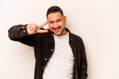 Genç İspanyol adam beyaz arka planda izole edilmiş dans ediyor ve eğleniyor..