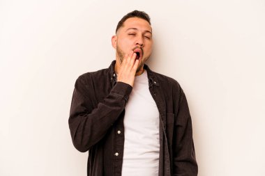 Beyaz arka planda izole edilmiş genç İspanyol adam esniyor. Ağzı eliyle kapatan yorgun bir hareket sergiliyor..