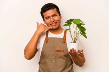 Genç bahçıvan İspanyol bir bitki tutuyor. Beyaz arka planda izole edilmiş. Cep telefonu hareketini parmaklarıyla gösteriyor..