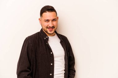 Beyaz arka planda izole edilmiş genç İspanyol bir adam. Kendine güveniyor. Kalçaları tutuyor..