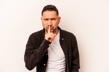 Beyaz arka planda izole edilmiş genç İspanyol bir adam ya sır saklıyor ya da sessizlik istiyor..