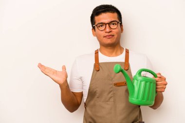 Genç bahçıvan, elinde su dolu bir kutu tutan beyaz arka planda bir fotokopi alanı ve belinde başka bir el tutan bir İspanyol..