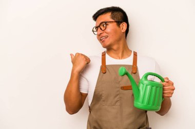 Genç bahçıvan İspanyol bir su bidonu tutuyor beyaz arka planda parmak uzakta, gülen ve kaygısız..