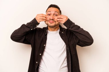 Latin kökenli genç bir adam beyaz arka planda iki seçenek arasında kuşkulanıyor..