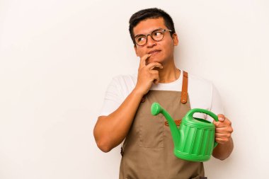 Genç bahçıvan İspanyol bir adam, beyaz arka planda izole edilmiş bir su bidonu tutuyor. Bir şeyin fotokopi odasına baktığını düşünerek rahatlıyor..