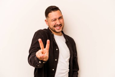 Beyaz arka planda izole edilmiş genç İspanyol adam iki numarayı parmaklarıyla gösteriyor..