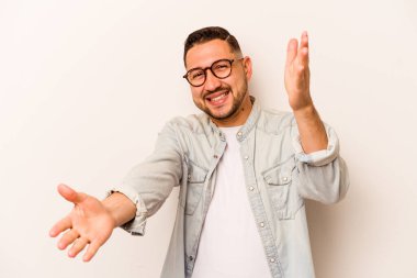 Beyaz arka planda izole edilmiş genç İspanyol adam kameraya sarıldığı için kendinden emin hissediyor..