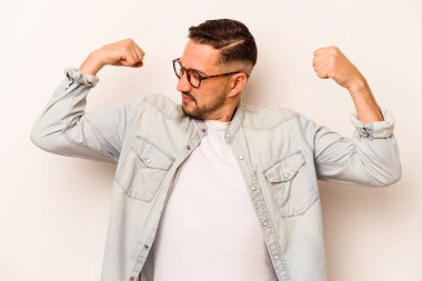 Beyaz arka planda izole edilmiş genç bir İspanyol kadın gücünün sembolü olan kollarıyla güçlü bir hareket sergiliyor.